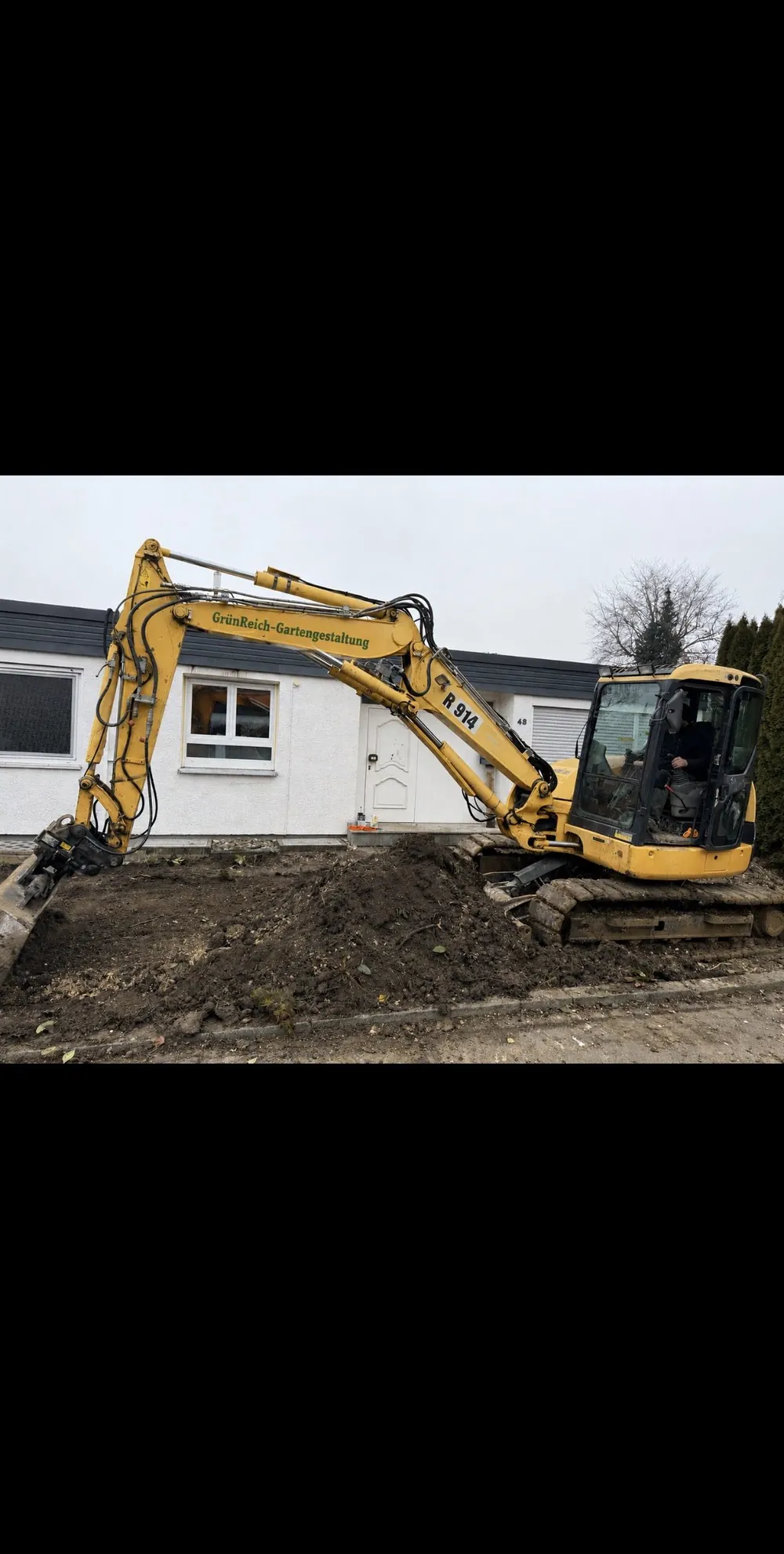 Bagger bei Erdarbeiten auf einer Gartenbaustelle